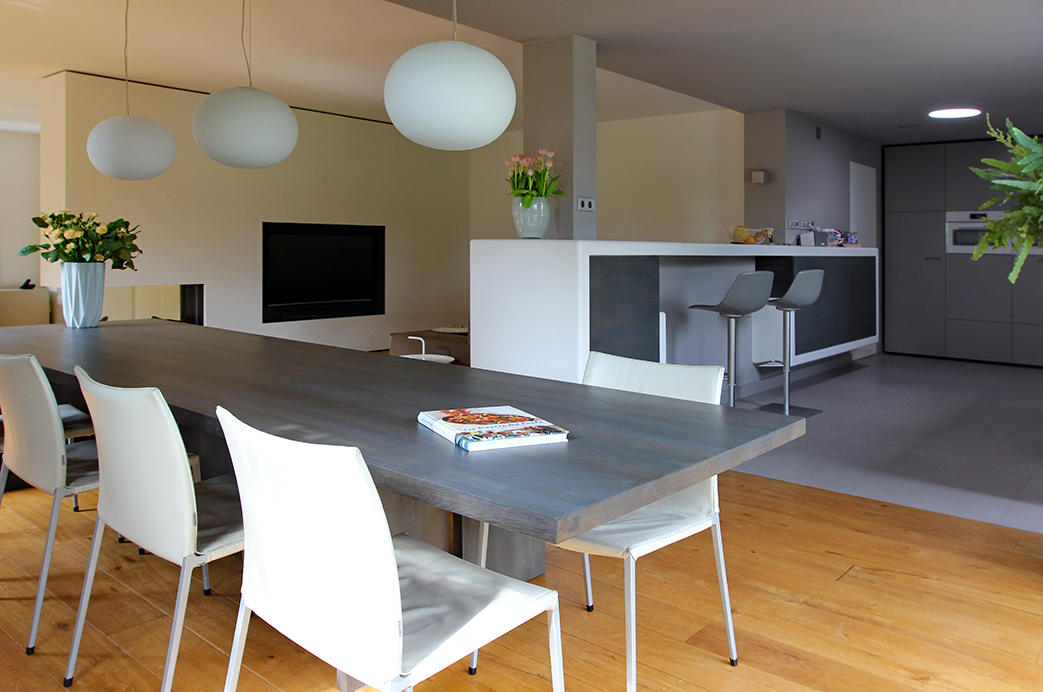 Keuken met bar van Hi-macs, tafel en keukendeurtjes van vergrijsd moeraseiken ontwerp van Leonardus interieurarchitect