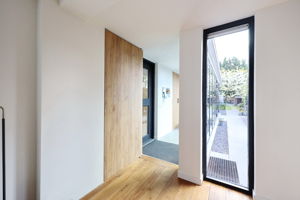 Aanbouw met handig weggewerkte taatsdeur in open positie met Noha deurgreep