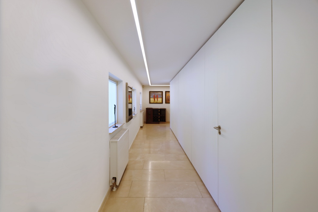 Gang met lichtlijn en kastenwand in villa te Hoogerheide door Leonardus en Paul de Bruijn Interieurarchitecten